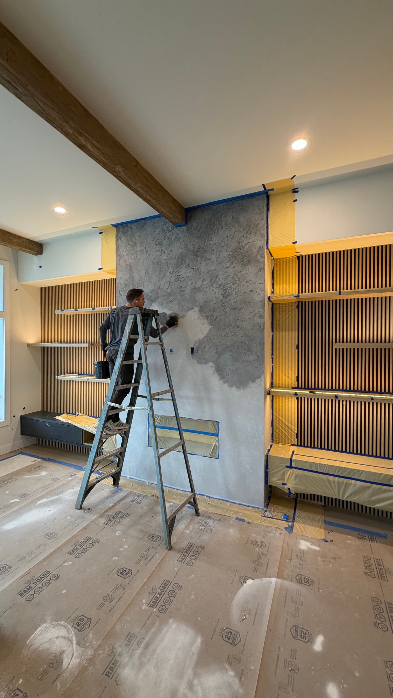 Artisan applying Venetian plaster texture to a fireplace in Portland OR